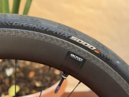 Close-up of Continental Grand Prix 5000 clincher tire mounted on a carbon road wheel, showing sidewall branding and tread pattern